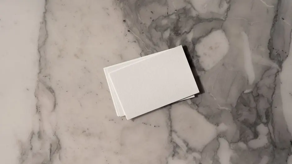 Stack of blank business cards on a marble background, ideal for mockup and design presentations.